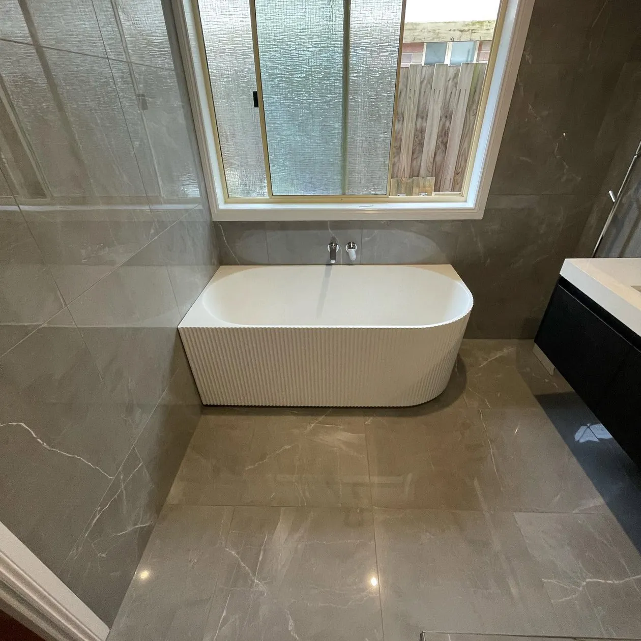 Fluted freestanding bath in a completed bathroom renovation