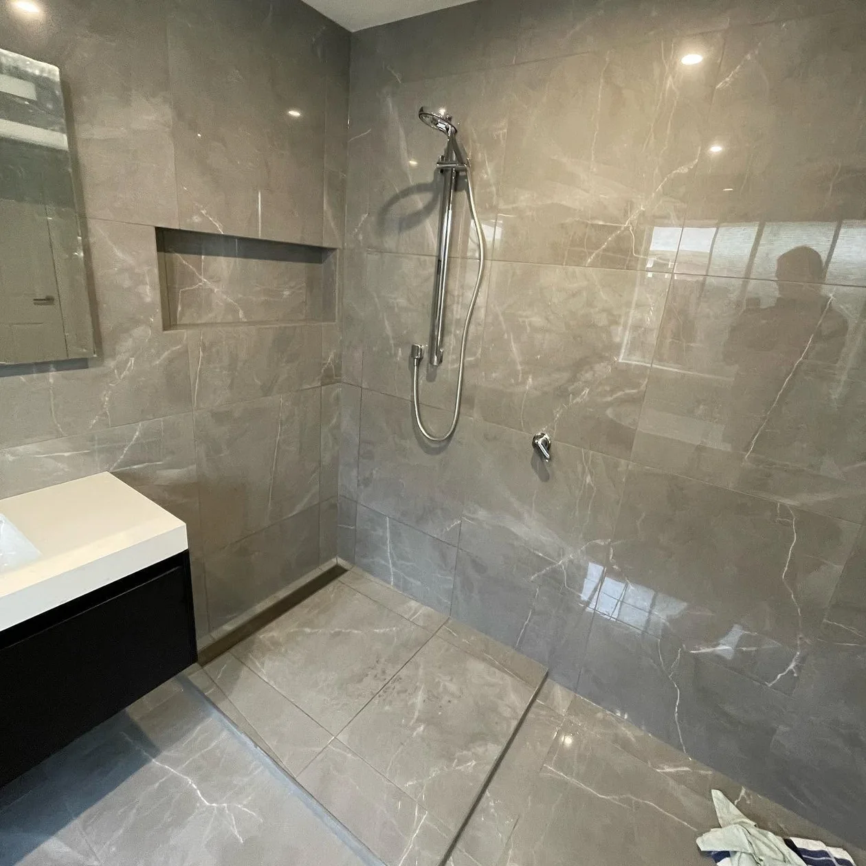 Completed bathroom with a walk-in shower and stone-look tiling
