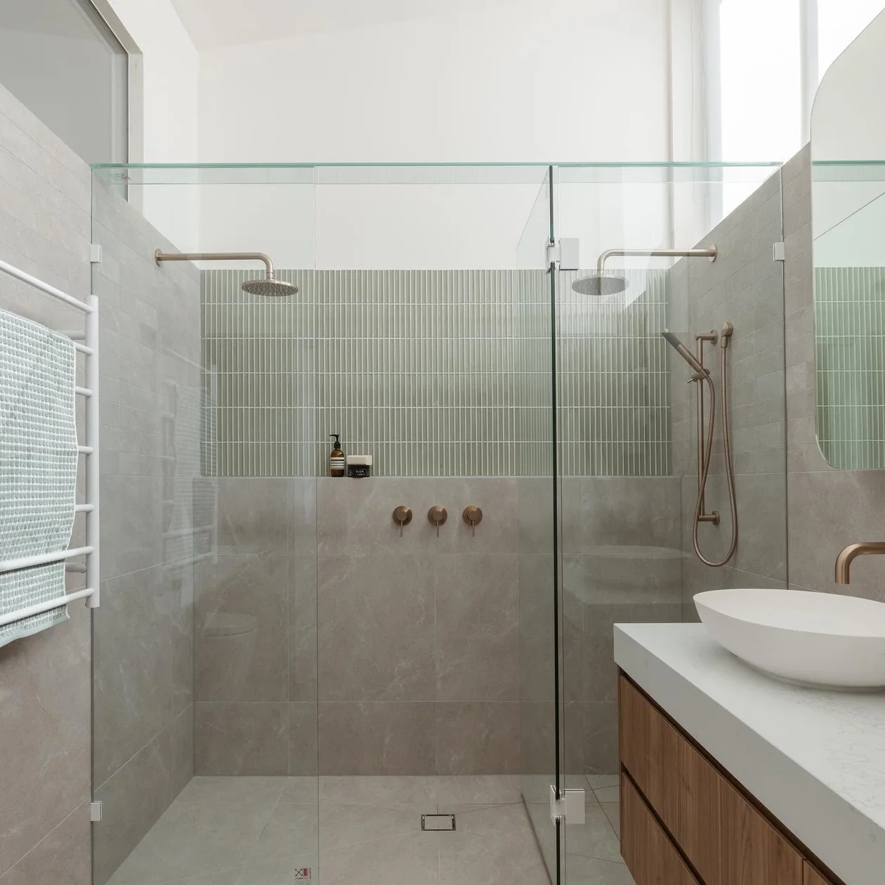 Completed bathroom with a walk-in shower and brass tapware
