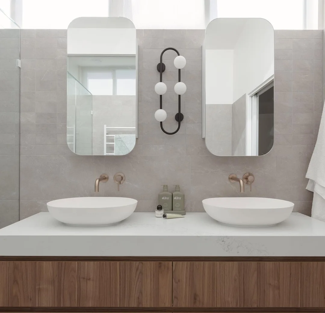 Twin basin vanity with brass tapware in a completed bathroom