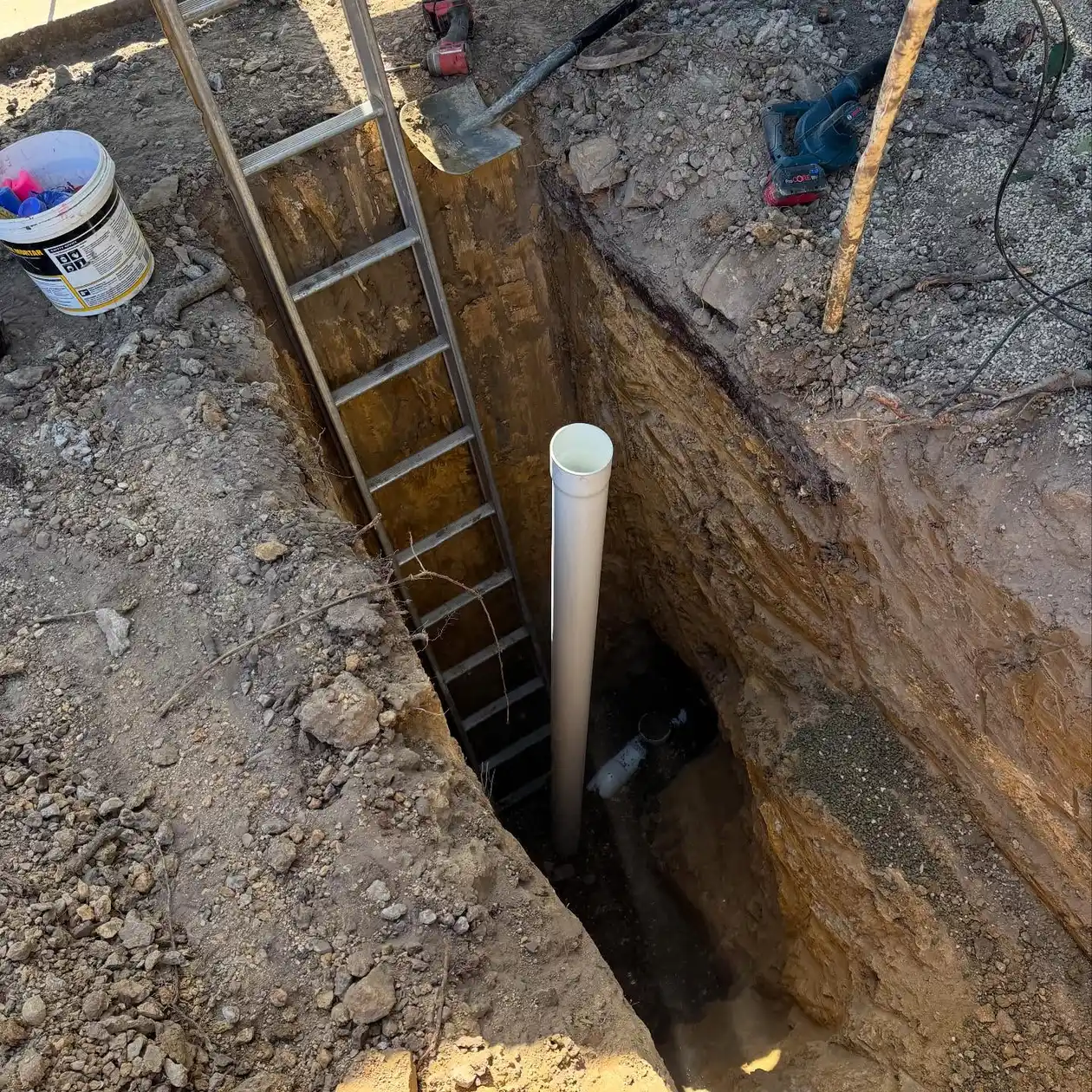 Deep excavation exposing a damaged underground drain line