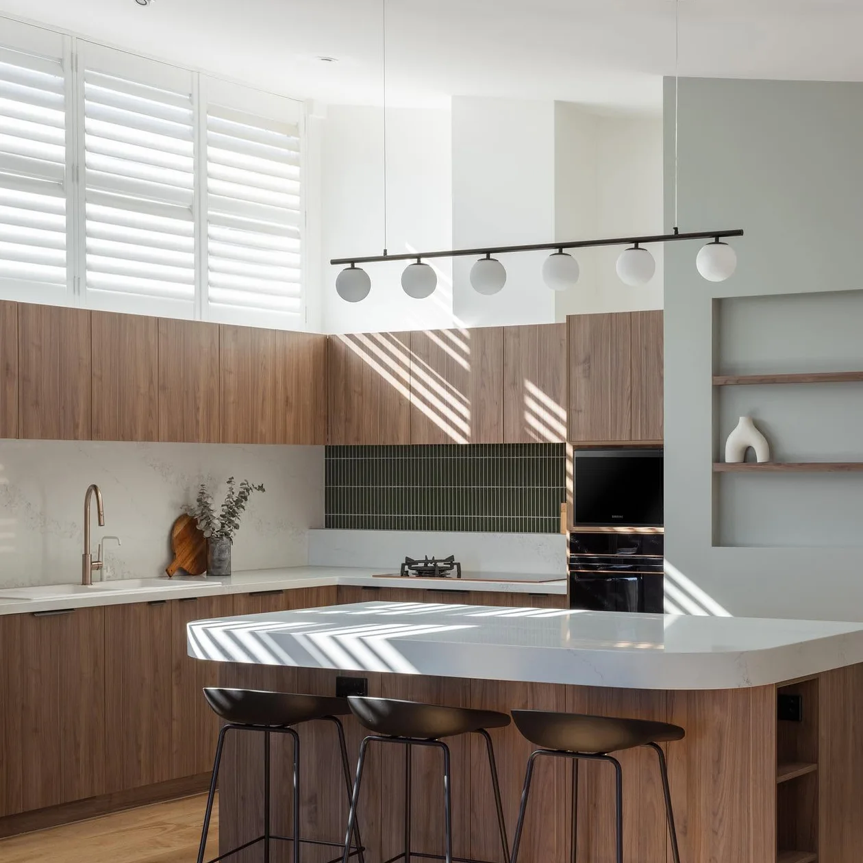 Completed kitchen renovation with timber cabinetry and a stone island bench