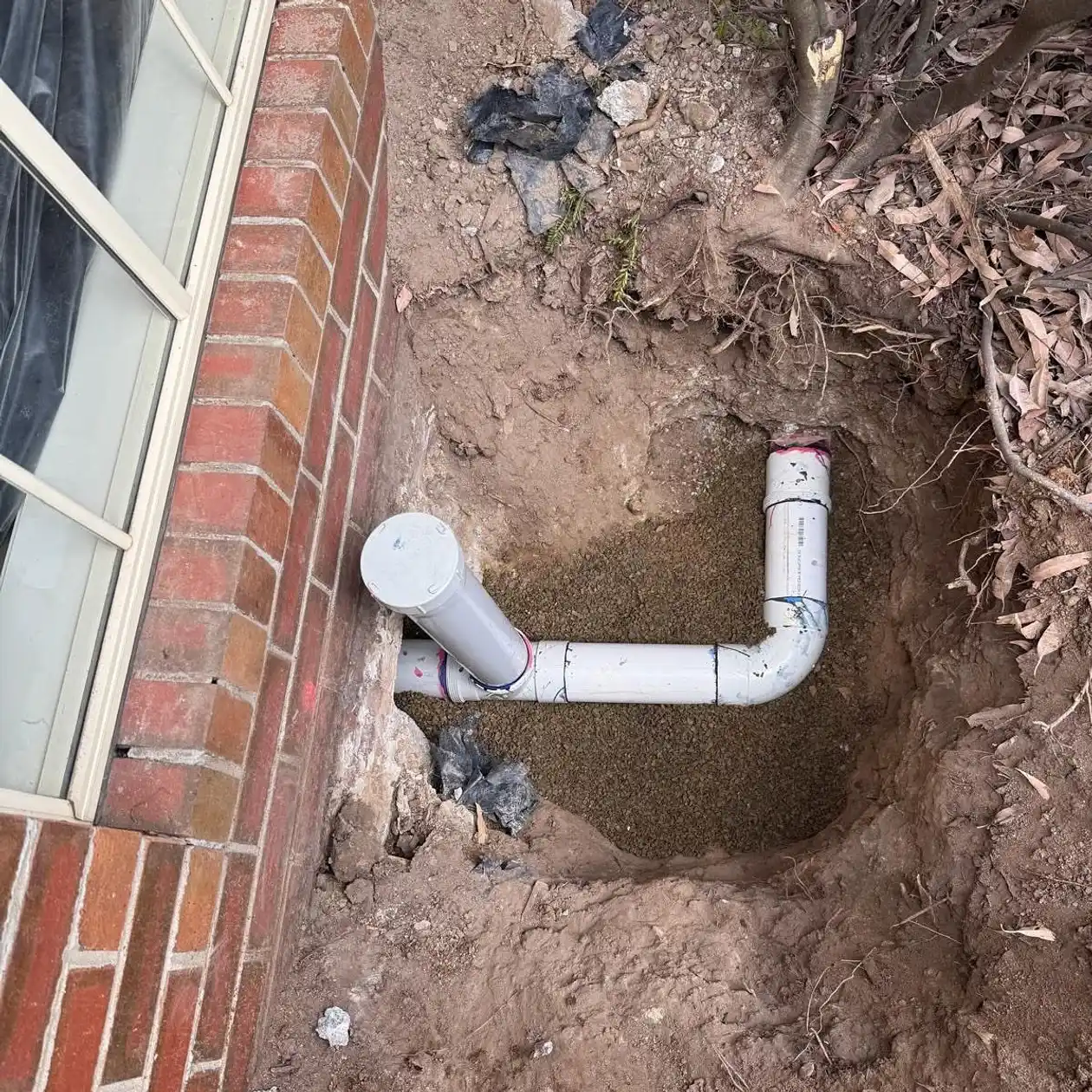 New drainage pipe installed and bedded in a trench