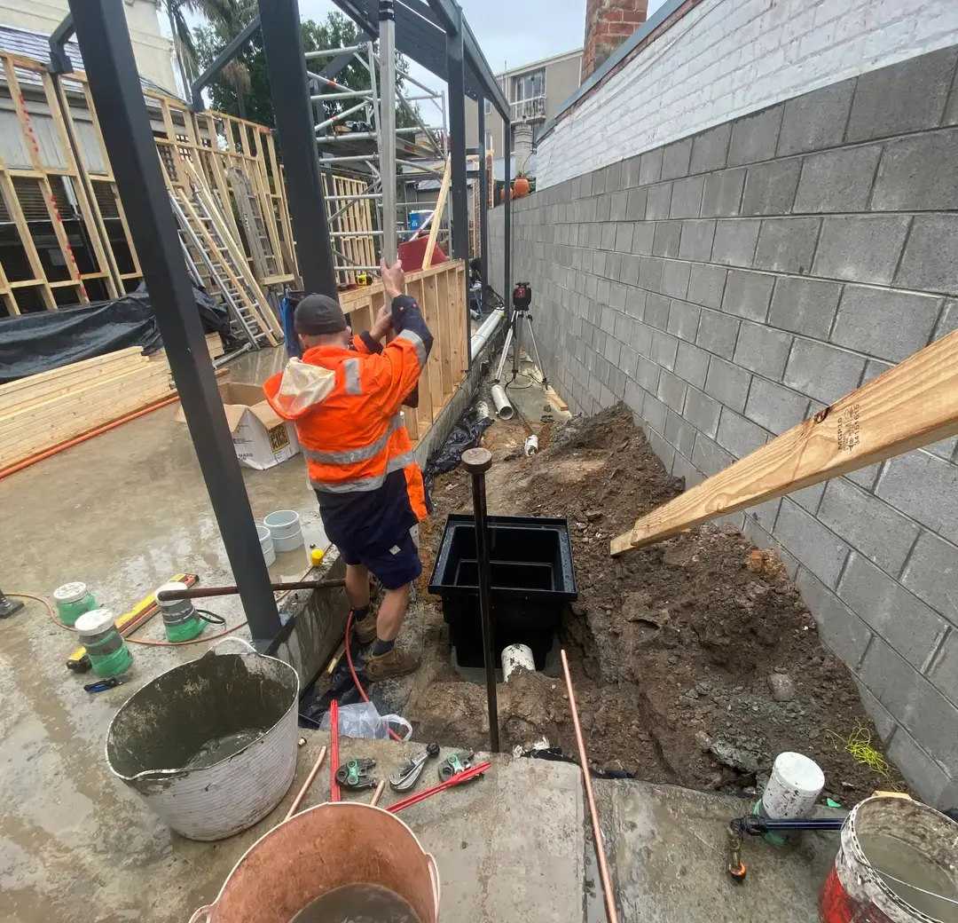 Plumber working on service pipework at a property