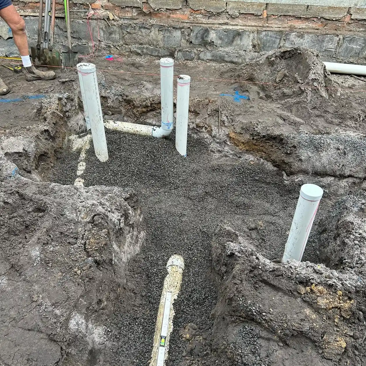 New sewer riser pipes set in a gravel bed on a residential site