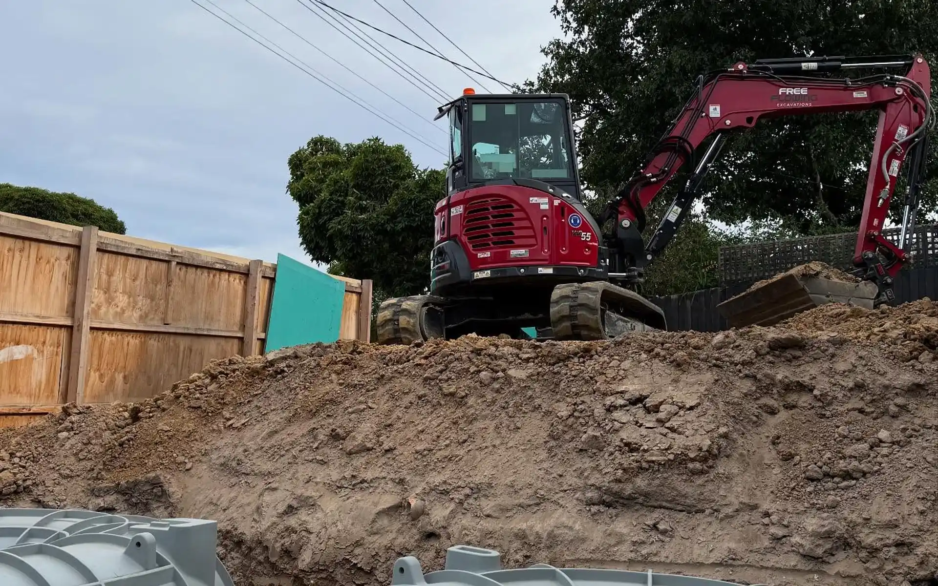 Excavator installing stormwater tanks on a large residential block