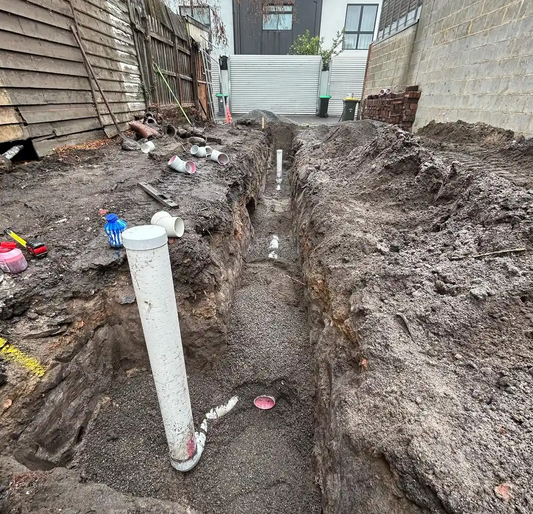 New stormwater pipes laid in an open trench in a back yard