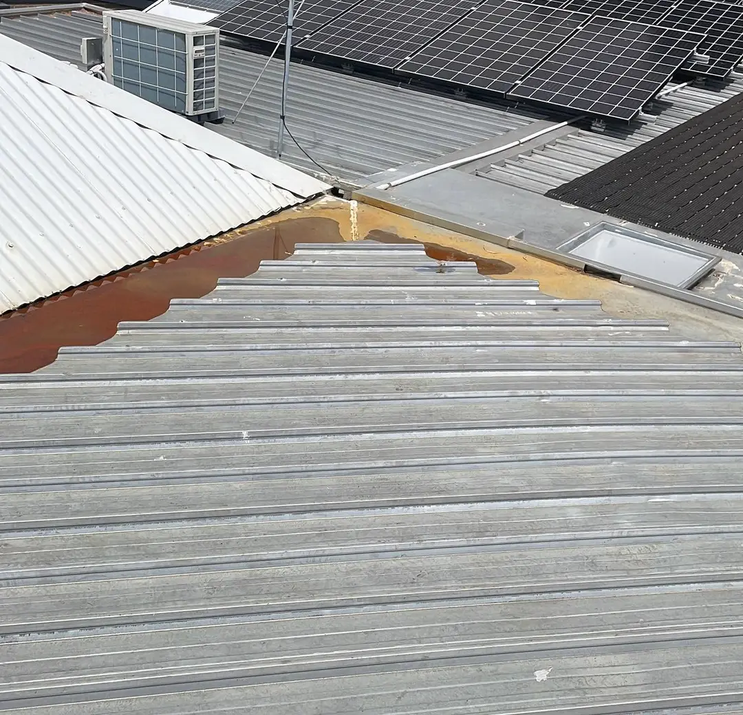 Weathered roof sheets and a box gutter on an existing roof