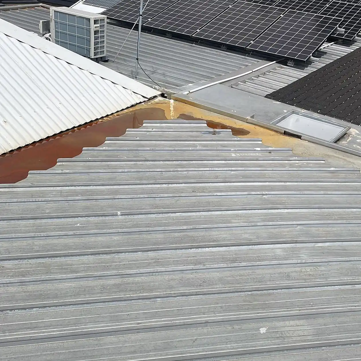 Weathered roof sheets and box gutter on an existing roof